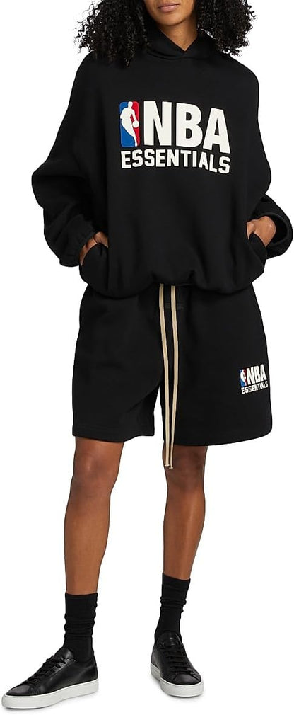 Person wearing an NBA Essentials hoodie and shorts set with hands in pockets.