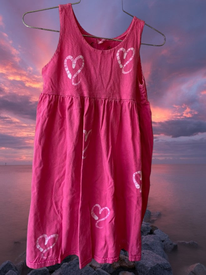 Pretty and flowy girl's pink sleeveless dress with heart pattern designs